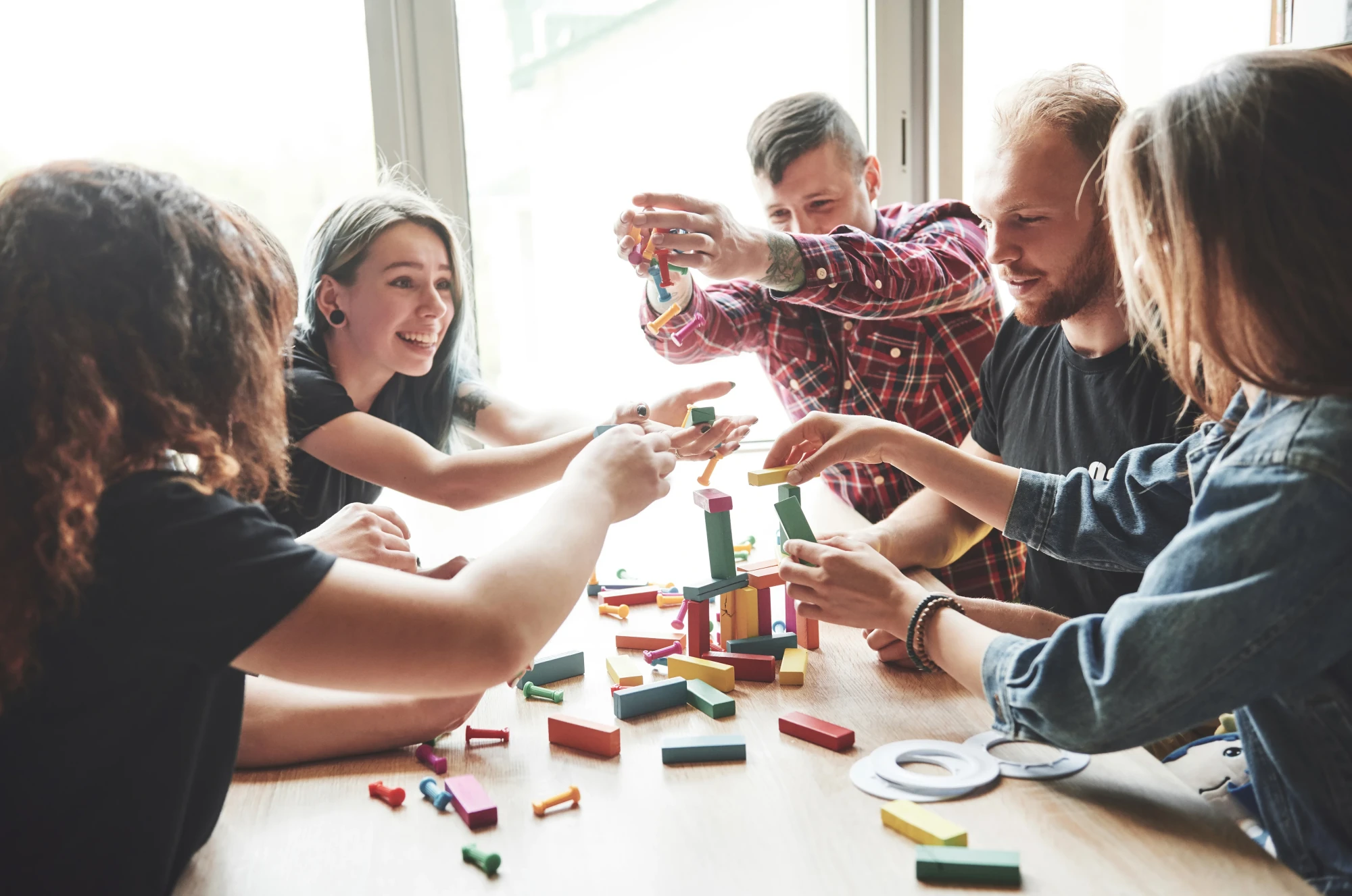 group-creative-friends-sitting-wooden-table-people-were-having-fun-while-playing-board-game